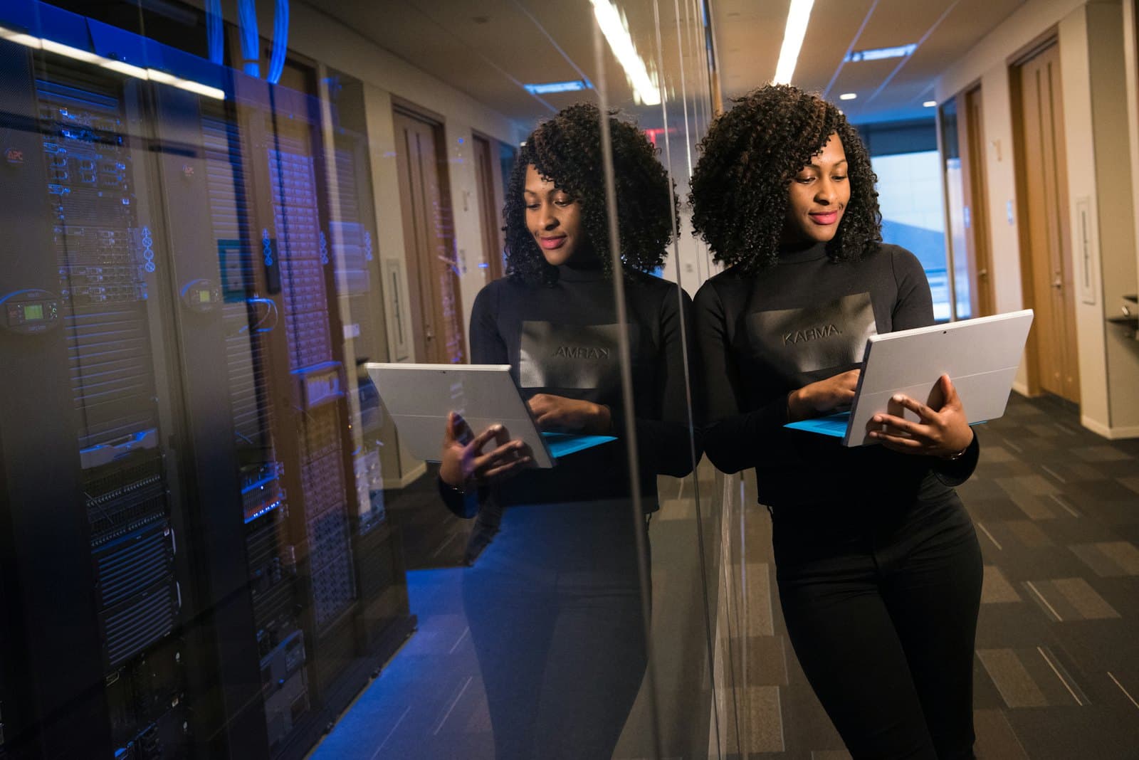 Une ingénieure consulte sa tablette dans une salle serveurs
